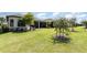 Lush backyard featuring green grass, beautiful trees, and a glimpse of the home's covered patio, ideal for gatherings at 1265 Zeek Ridge St, Clermont, FL 34715