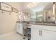 Bright bathroom featuring double sink vanity, granite countertops, white cabinets, and framed wall art at 1265 Zeek Ridge St, Clermont, FL 34715