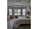 Cozy bedroom with tray ceiling, plantation shutters, and neutral color palette at 1265 Zeek Ridge St, Clermont, FL 34715