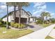Attractive home with a brick driveway, two-car garage, and well-maintained landscaping featuring palm trees and shrubs at 1265 Zeek Ridge St, Clermont, FL 34715