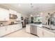 Modern kitchen with white cabinetry, stainless steel appliances, tile backsplash and granite countertops at 1265 Zeek Ridge St, Clermont, FL 34715