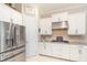 Bright kitchen with stainless steel refrigerator and appliances, white cabinetry, and tile floors at 1265 Zeek Ridge St, Clermont, FL 34715