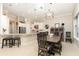 Bright eat-in kitchen features white cabinets, stainless appliances, a granite island and tiled flooring at 1265 Zeek Ridge St, Clermont, FL 34715