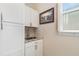 Well-organized laundry area with a sink, granite countertops, white cabinets, and a view from the window at 1265 Zeek Ridge St, Clermont, FL 34715