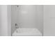 Bright bathroom featuring a bathtub and shower with white tile surround at 12863 Harvest Rain Ave, Winter Garden, FL 34787