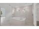 Modern bathroom features a glass enclosed shower and bathtub combo with tile surround at 12863 Harvest Rain Ave, Winter Garden, FL 34787