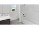 Bright bathroom boasts a shower-tub combo, single window, and dark wood cabinet at 12863 Harvest Rain Ave, Winter Garden, FL 34787
