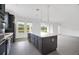 Well-equipped kitchen with stainless steel appliances, gray cabinets, a center island, and plenty of natural light at 12863 Harvest Rain Ave, Winter Garden, FL 34787