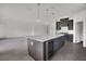 Spacious kitchen includes an island with a wine cooler and sleek gray cabinetry at 12863 Harvest Rain Ave, Winter Garden, FL 34787