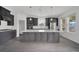 Modern kitchen featuring gray cabinets, a large center island, stainless steel appliances, and sleek countertops at 12863 Harvest Rain Ave, Winter Garden, FL 34787