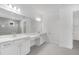 Elegant primary bathroom with double vanity, large mirror, and a walk-in glass shower at 12869 Harvest Rain Ave, Winter Garden, FL 34787