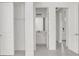 Hallway with open doors leading to bathroom and other rooms with grey tile flooring at 12869 Harvest Rain Ave, Winter Garden, FL 34787
