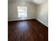 Cozy bedroom featuring hardwood flooring and a bright window with a view at 1310 Polk City Rd, Haines City, FL 33844