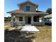 Charming two-story home featuring a cozy front porch with arched entryways and a freshly poured concrete walkway at 1310 Polk City Rd, Haines City, FL 33844