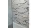 Close-up of a shower featuring elegant marble-look tile, and a sliding glass door at 1310 Polk City Rd, Haines City, FL 33844