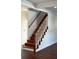 Elegant staircase featuring natural wood steps, white risers, and a wood handrail, blending classic design with modern appeal at 1310 Polk City Rd, Haines City, FL 33844