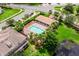Aerial view of community pool with covered patio and palm trees next to a pond at 13430 Early Frost Cir, Orlando, FL 32828