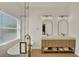 Luxury bathroom showcasing a soaking tub, dual vanities, and a glass enclosed shower at 13430 Early Frost Cir, Orlando, FL 32828