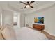 Spacious bedroom featuring modern decor, tray ceiling, a ceiling fan and an entertainment center at 13430 Early Frost Cir, Orlando, FL 32828