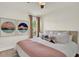Comfortable bedroom with modern decor, artwork, ceiling fan, and a large window at 13430 Early Frost Cir, Orlando, FL 32828