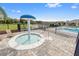 Community hot tub with mushroom shaped sprinkler feature and brick patio at 13430 Early Frost Cir, Orlando, FL 32828