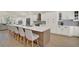 Bright kitchen with white cabinets, a large island with seating, and stainless steel appliances at 13430 Early Frost Cir, Orlando, FL 32828