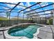 Enclosed pool features a small in ground spa and a black mesh enclosure and a gray deck at 13430 Early Frost Cir, Orlando, FL 32828