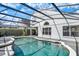 Clear blue pool with a gray patio and a white house, enclosed in black mesh to prevent bugs at 13430 Early Frost Cir, Orlando, FL 32828
