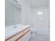 Bright bathroom featuring a tub with tile surround and a white vanity with wood accents at 13434 Mallard Cove Blvd, Orlando, FL 32837