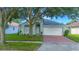 Charming single-story home with a brick driveway, mature trees, and a well-maintained lawn at 13434 Mallard Cove Blvd, Orlando, FL 32837