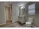 This bathroom features a modern vanity, toilet, and wood-look floors at 136 Country Club Dr, Sanford, FL 32771