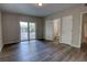 Open bedroom layout with modern gray wood-look flooring and access to a bathroom and sliding glass door at 136 Country Club Dr, Sanford, FL 32771