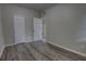 Bedroom with modern gray wood-look flooring and access to an adjacent room at 136 Country Club Dr, Sanford, FL 32771