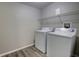 Functional laundry room with white washer and dryer, and modern gray wood-look flooring at 136 Country Club Dr, Sanford, FL 32771