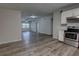 Bright living space with luxury vinyl plank flooring leading to the kitchen featuring stainless appliances at 136 Country Club Dr, Sanford, FL 32771