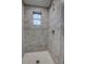 The updated shower features marble-look tiles and a pebble-tile floor at 136 Country Club Dr, Sanford, FL 32771