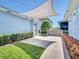 Inviting backyard featuring concrete pavers, a sunshade, and manicured landscaping at 13662 Behring Ave, Orlando, FL 32827