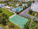 Aerial view of the community's well-maintained basketball court, surrounded by tropical trees and lush landscaping at 13662 Behring Ave, Orlando, FL 32827