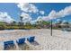 A scenic beach volleyball court with chairs, palm trees, and serene blue skies, ready for community fun at 13662 Behring Ave, Orlando, FL 32827