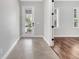 Hallway with tile flooring leading to a bedroom with hardwood floors and natural light at 13662 Behring Ave, Orlando, FL 32827