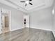 Spacious main bedroom with tray ceiling, ceiling fan, and wood-look flooring at 13662 Behring Ave, Orlando, FL 32827