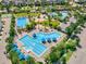Aerial view showcasing a community pool area with multiple pools, palm trees, and lounge areas at 13662 Behring Ave, Orlando, FL 32827