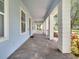 Covered porch featuring brick flooring, columns, and a view of the well-maintained landscaping at 13662 Behring Ave, Orlando, FL 32827