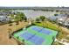 Aerial view of the community's tennis courts showcasing well maintained courts surrounded by lush landscape and a pond at 13662 Behring Ave, Orlando, FL 32827