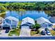 Charming blue home with lake view, surrounded by lush greenery, and neighboring properties at 148 Meadow Blvd, Sanford, FL 32771
