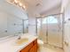Bright bathroom features a glass-enclosed shower, white countertops, and a wood vanity at 148 Meadow Blvd, Sanford, FL 32771