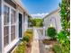 Charming side yard with a white picket fence and lush green landscaping and plants at 148 Meadow Blvd, Sanford, FL 32771
