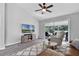 Well-lit living room with modern gray floors, ceiling fan, and sliding doors to the outside patio at 1527 Braewick St, Winter Springs, FL 32708