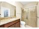 Bathroom boasts granite counters, wood cabinets, and a glass-enclosed shower at 15366 Sandfield Loop, Winter Garden, FL 34787