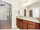 Bathroom vanity with wood cabinets, granite countertops, and a large mirror at 15366 Sandfield Loop, Winter Garden, FL 34787